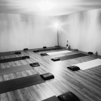 Black & White image of multiple yoga mats set up in line for a stretch class